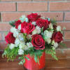 12 roses accented with premium fillers and greenery in a clear cylinder