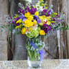 Extra large mason jar filled with spring iris, tulips, green hydrangeas, stock