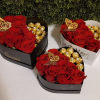 Romantic heart-shaped box with fresh roses and chocolates.