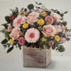 A combination of blooms arranged in a wooden cube. Perfect for any