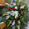 Featuring red, white and blue flowers along with a ribbon and flag