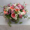GARDEN ROSES, DIFFERENT VARIETIES OF RANUNCULUS, LISIANTHUS, ALSTROMERIAS, TEXTURAL GREENERY, AND CYMBIDIUM