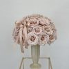 A chic, modern vase adorned with beautiful beige roses, exuding a sense