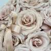 A chic, modern vase adorned with beautiful beige roses, exuding a sense