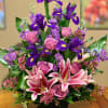 Purple Roses, Purple Stock, Iris, Stargazer Lilies, Wax Flowers And Tropical Leaves