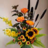 This masculine tribute shows you care with sunflowers, roses, millet, gladiolas, and