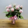 A dozen pink roses with variegated pittosporum and salal in a beautiful