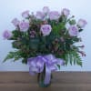 12 purple roses, with variegated pittosporum and salal, arrive in a classic