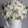 An elegant blend of beige and white roses, soft hydrangeas, eucalyptus, and