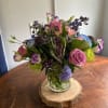 a beautiful purple and blue arrangement in a clear cylinder vase with
blue
