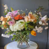A stunning array of spring florals arranged in a glass cylinder vase.