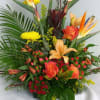 Tropical arrangement in oranges, yellows and reds with bird of paradise, orange