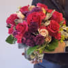This stunning arrangement features deep red Roses, complemented by vibrant pink Carnations