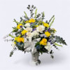 This arrangement has yellow and white roses, white mums, monte casino, iris