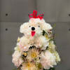 All white poodle with a range of mixed white flowers and pink