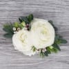 This corsage is more petite in size and features white ranunculus, and