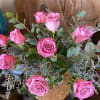 Dozen long stem lavender roses with filler designed in a glass vase.