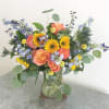 With cheerful sunflowers, yellow billy balls, sky-blue delphinium and heavily petaled garden