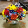 Festive arrangement with roses, carnations, asters, daisies and colorful curling ribbon 