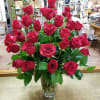 Forty long stem red roses in a vase with greenery. 