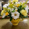 Daisies, carnations and spray roses in a happy face mug with greenery
