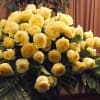 Pale Yellow  Roses(Candlellight) ,  Palms, Fancy Greens are elegantly arranged