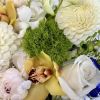 A unique flower arrangement featuring white and blue flowers with accents of
