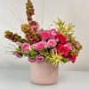 A bright and joyful floral arrangement bursting with pink, white roses, 
