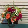 Assorted hot pinks and oranges roses and spray roses with accents of