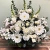 Assorted white flowers arranged on one side of the basket.  Suitable