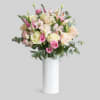 his is a delicate and elegant floral arrangement featuring a mix of