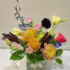 A stylish floral arrangement featuring soft pastel blooms with a bold pop