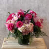 This stunning floral arrangement combines the elegance of soft pink hydrangeas, the