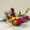 A burst of color and joy, this vibrant arrangement combines a lively