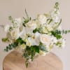 This ethereal arrangement showcases an organic selection of classic white blooms including