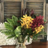Red and yellow flowers encased by greenery create an arrangement reminiscent of