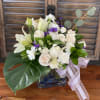 A combination between tropical leaves, blush roses, and white lilies.