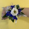 A combination of white lisianthus and blue delphinium, on a silver ribbon.
