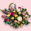A fun and feminine arrangement of tulips, spray roses, and ranunculus. This