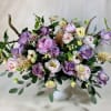 Modern floral arrangement with deep antique purple roses, pink peonies, butterfly ranunculus