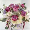 Deep purple roses, white hydrangeas, soft lilac stocks, pink ranunculus and other
