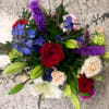 A sleek mixed arrangement that showcases vibrant Spring colors, featuring roses, astatic