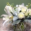 A tranquil mixed arrangement that showcases a pristine all-white ensemble of flowers