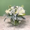 A tranquil mixed arrangement that showcases a pristine all-white ensemble of flowers