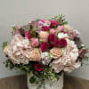 Flower arrangement in white ceramic container with beautiful combination of light pink