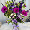 Wonderful floral arrangement in a glass base with gerberas, tulips, speedwells, lilies
