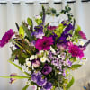 Wonderful floral arrangement in a glass base with gerberas, tulips, speedwells, lilies