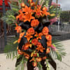 Funeral spray with an orange and black theme. 

*Order must be placed
