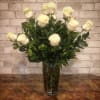 Twelve beautiful big headed long stemmed white roses arranged in a bed