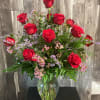 Beautiful display of one dozen long stemmed red roses adorned with luscious